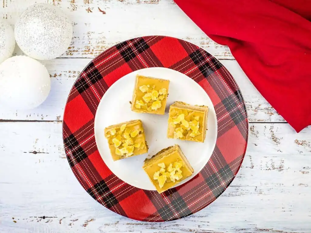 A plate with four squares of triple ginger cake bars on it.