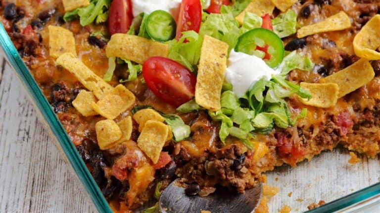 Mexican casserole in a glass dish with a spoon.