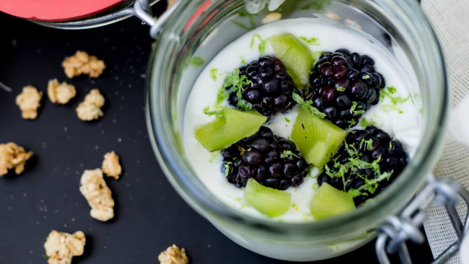 An easy breakfast of yogurt with blackberries and granola served in a jar.