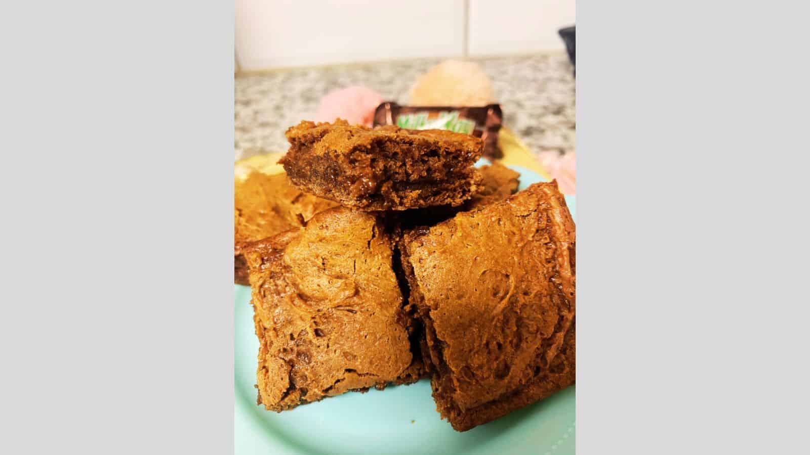 Pile of Milky Way brownies on light blue plate.