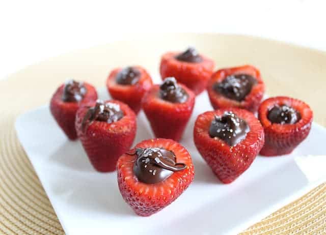 Chocolate stuffed strawberries on a white plate.