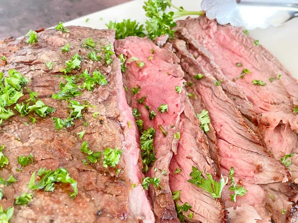 Sliced beef on a white platter.