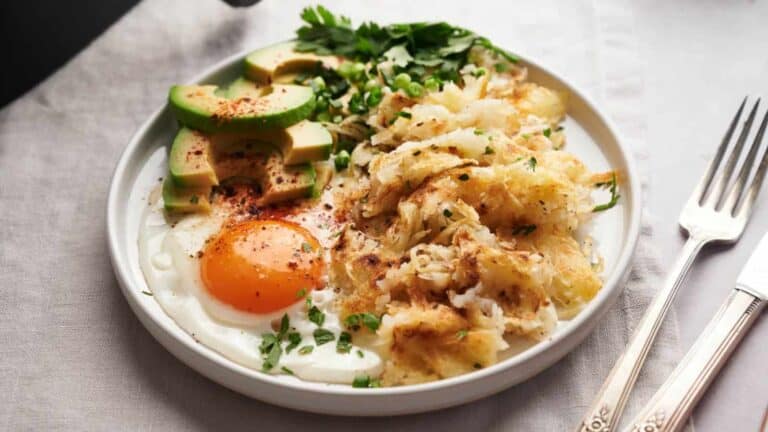 A bowl of mashed potatoes with an egg and avocado.