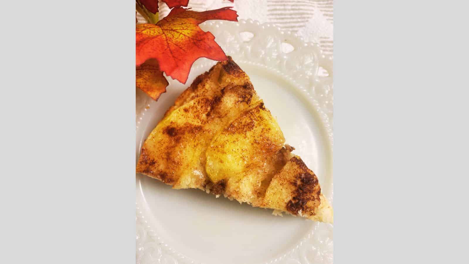 Slice of apple coffee cake on white plate.