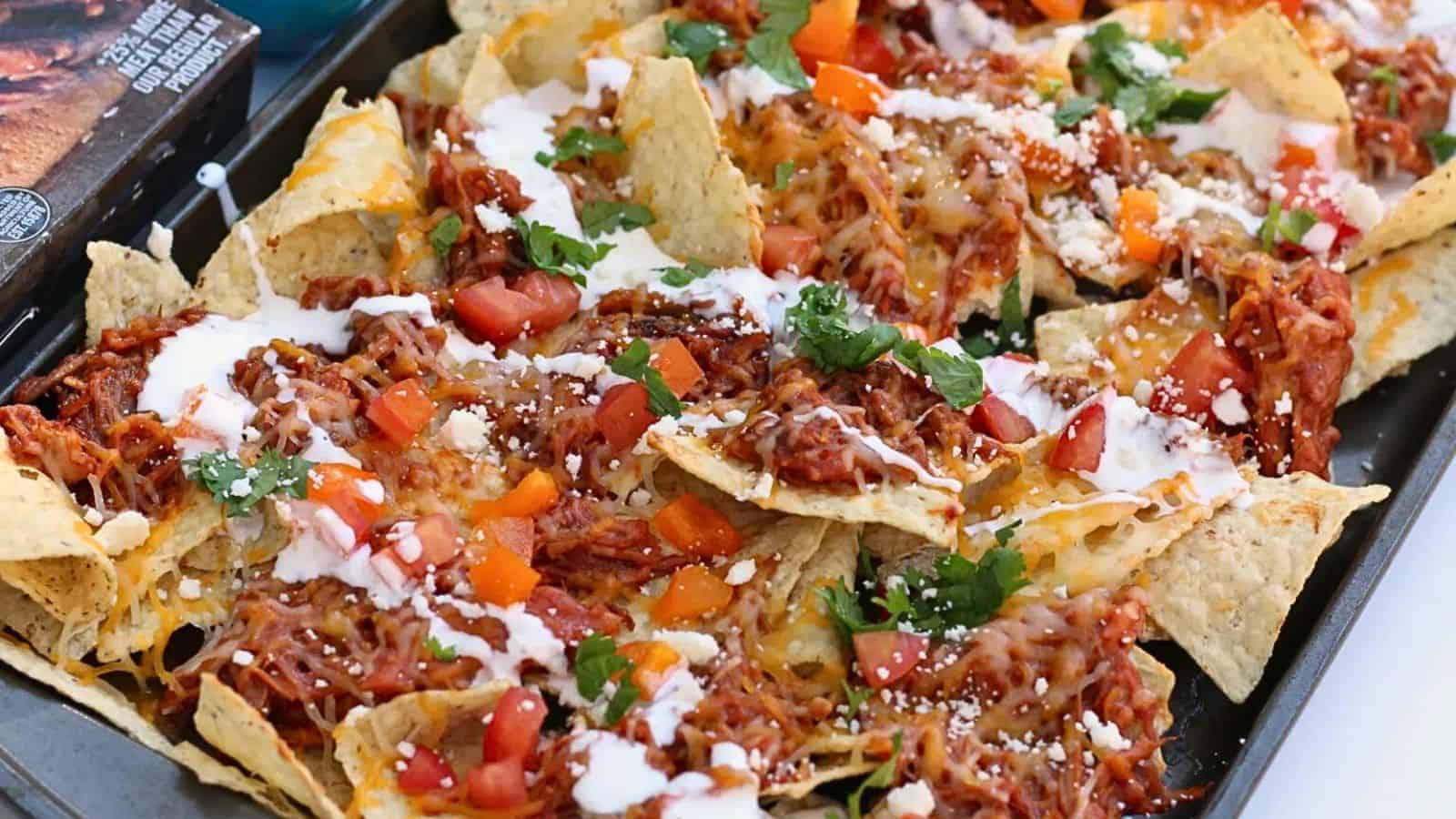 Sheet pan of nachos - topped with pulled pork, cheese, veggies, etc.