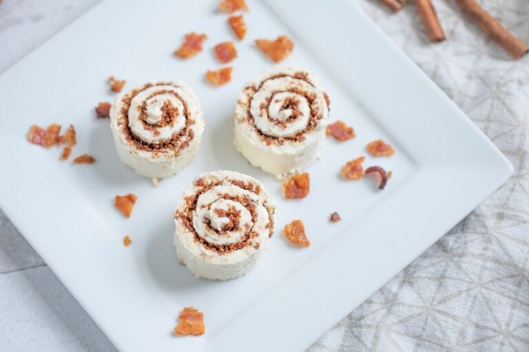 A white plate with three cinnamon rolls on it.