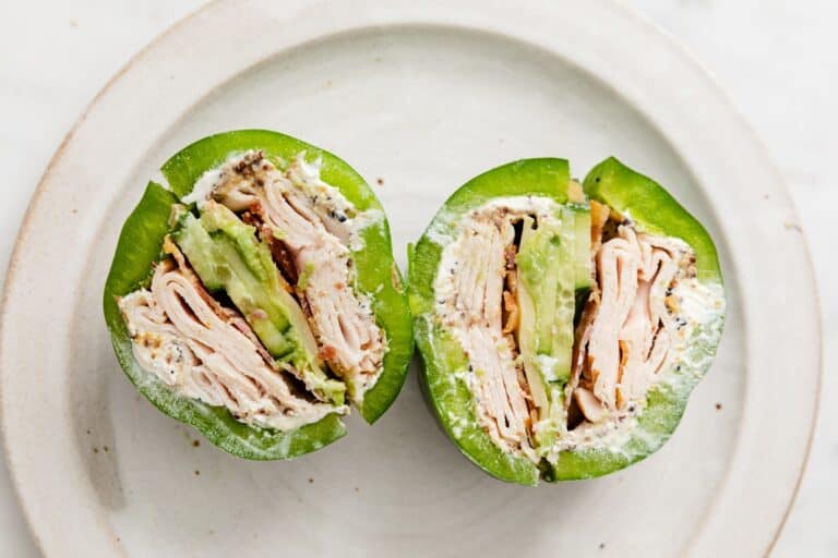 Two slices of a bell pepper sandwich on a plate.