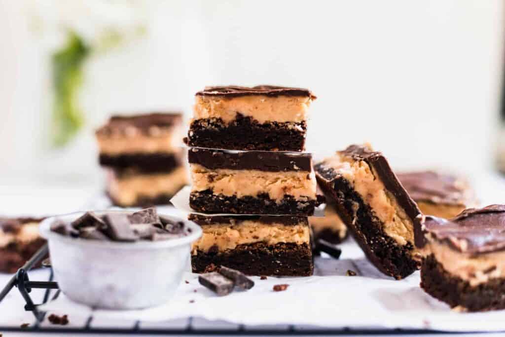 A stack of chocolate peanut butter bars on a cooling rack.