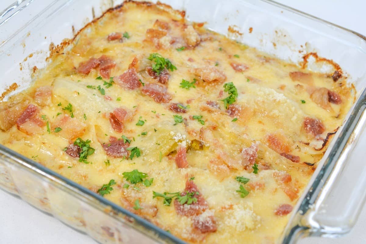 A casserole dish filled with cabbage, cheese and bacon.