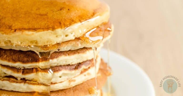 A stack of pancakes is being drizzled with syrup.