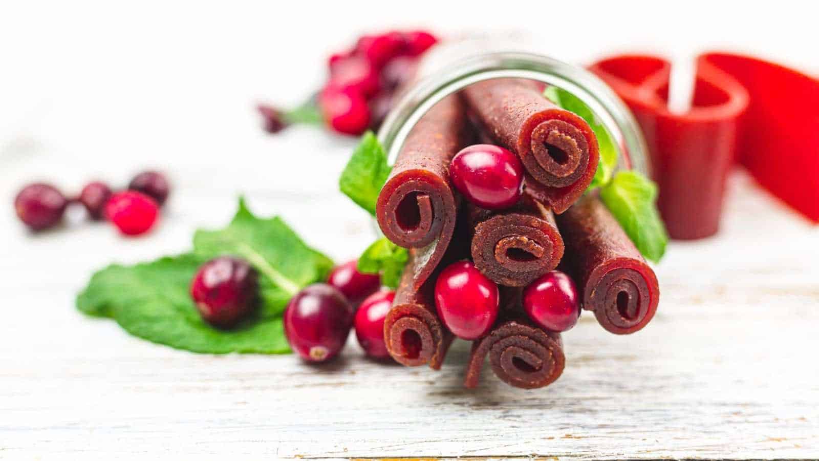 A jar of cranberry leather on a wooden table.