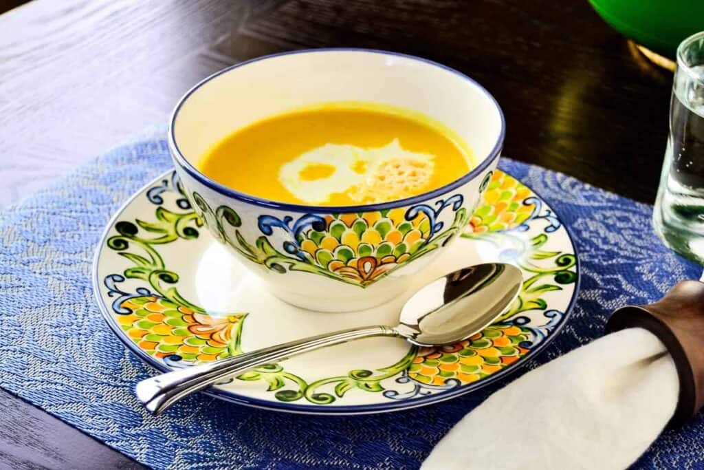         A bowl of soup on a blue and white plate, perfect for soup recipes.