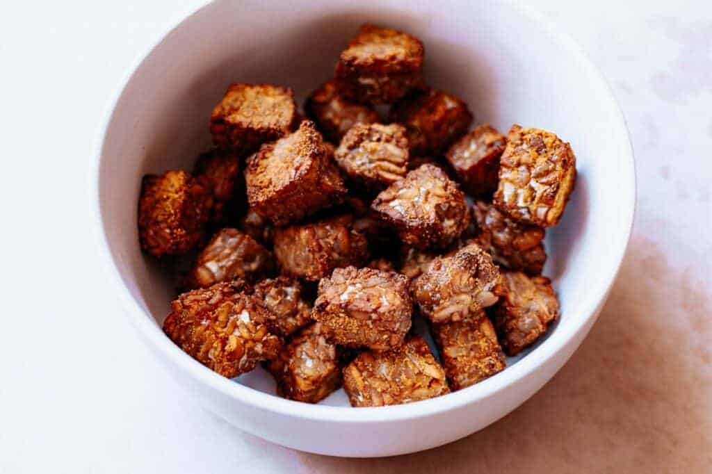 A white bowl filled with granola cubes.