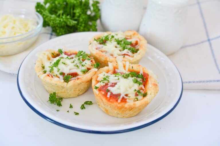 A plate with four mini pizzas on it.