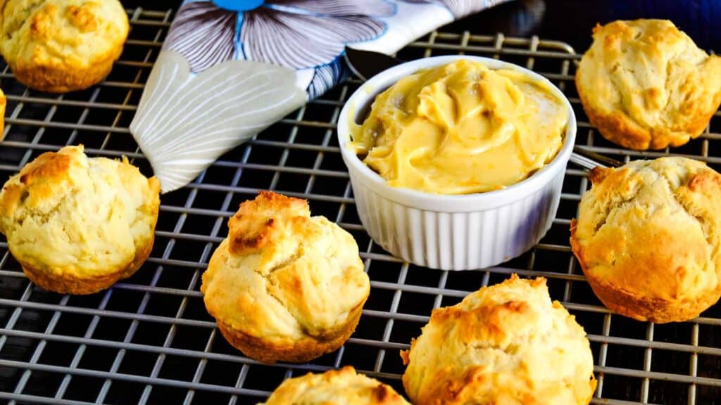 Biscuits on a cooling rack with a bowl of dipping sauce.