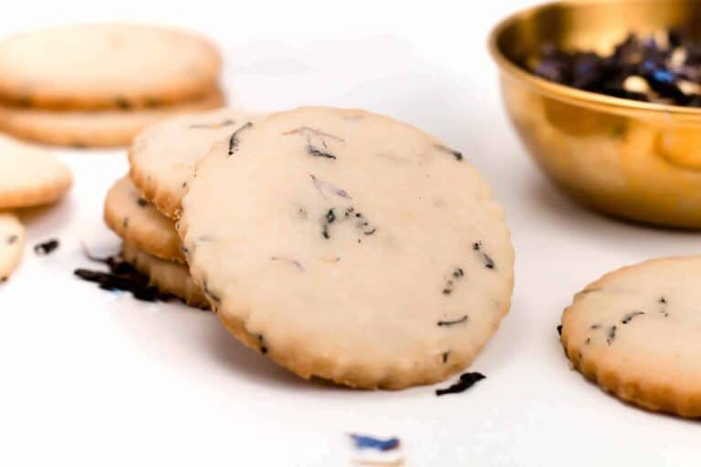 A bowl of cookies next to a bowl of tea.