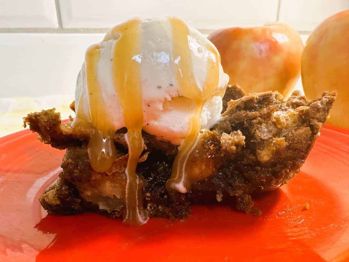 A piece of apple bar with ice cream and caramel sauce.