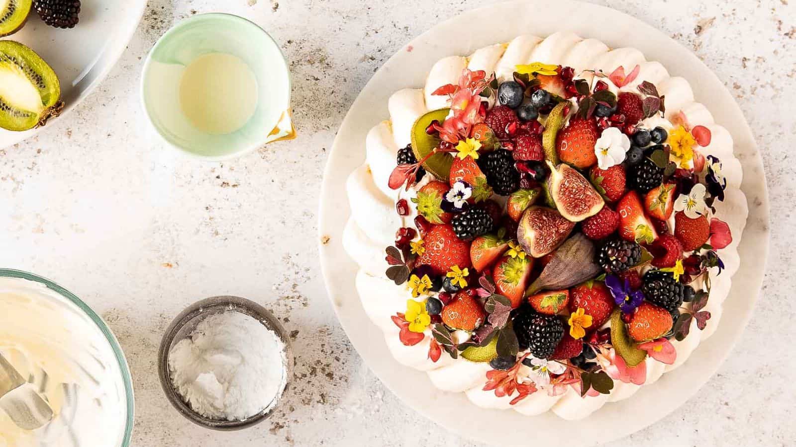 A pavlova topped with berries and figs.