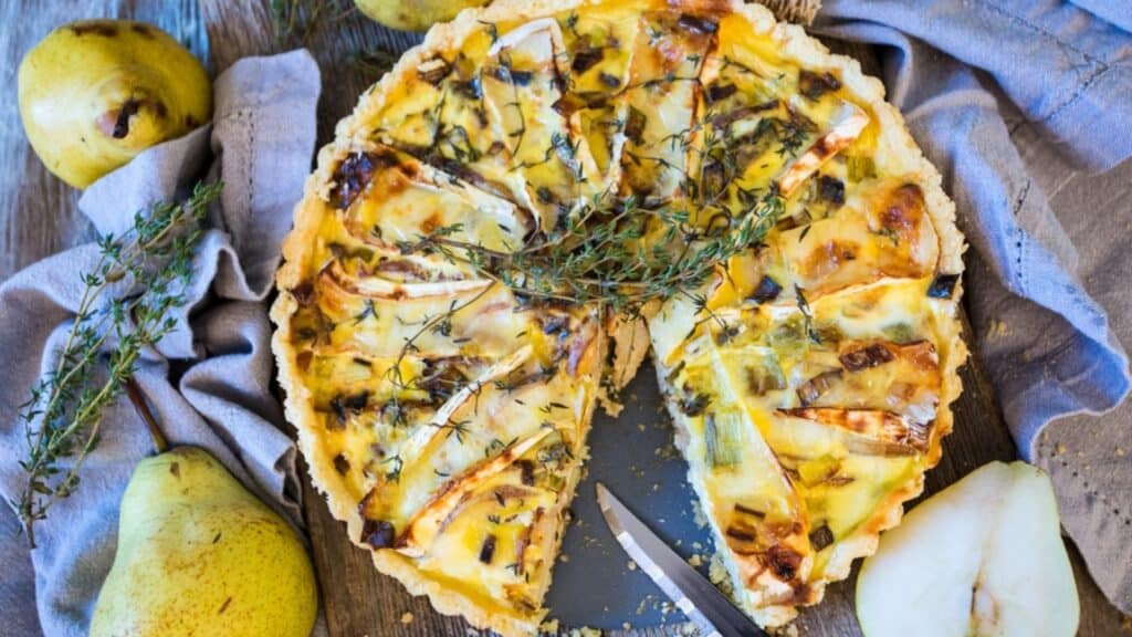 A quiche with pears and sprigs of thyme.