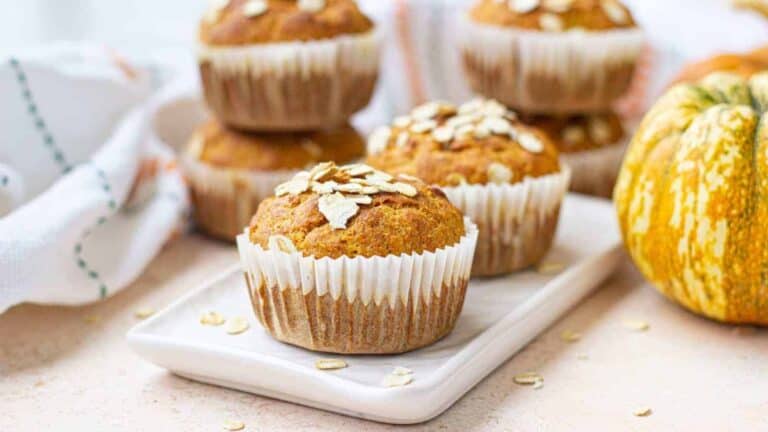 Pumpkin muffins on a white plate with pumpkins.