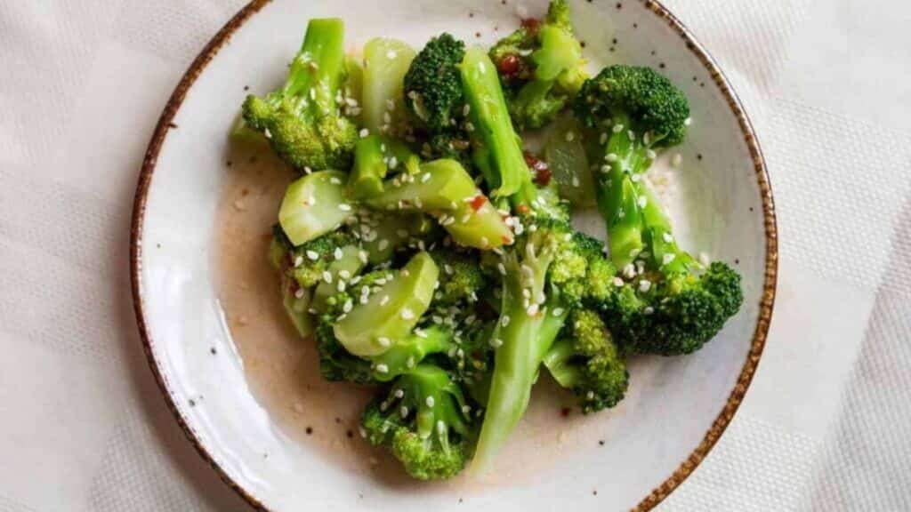 A plate of broccoli with sesame seeds and sesame oil.