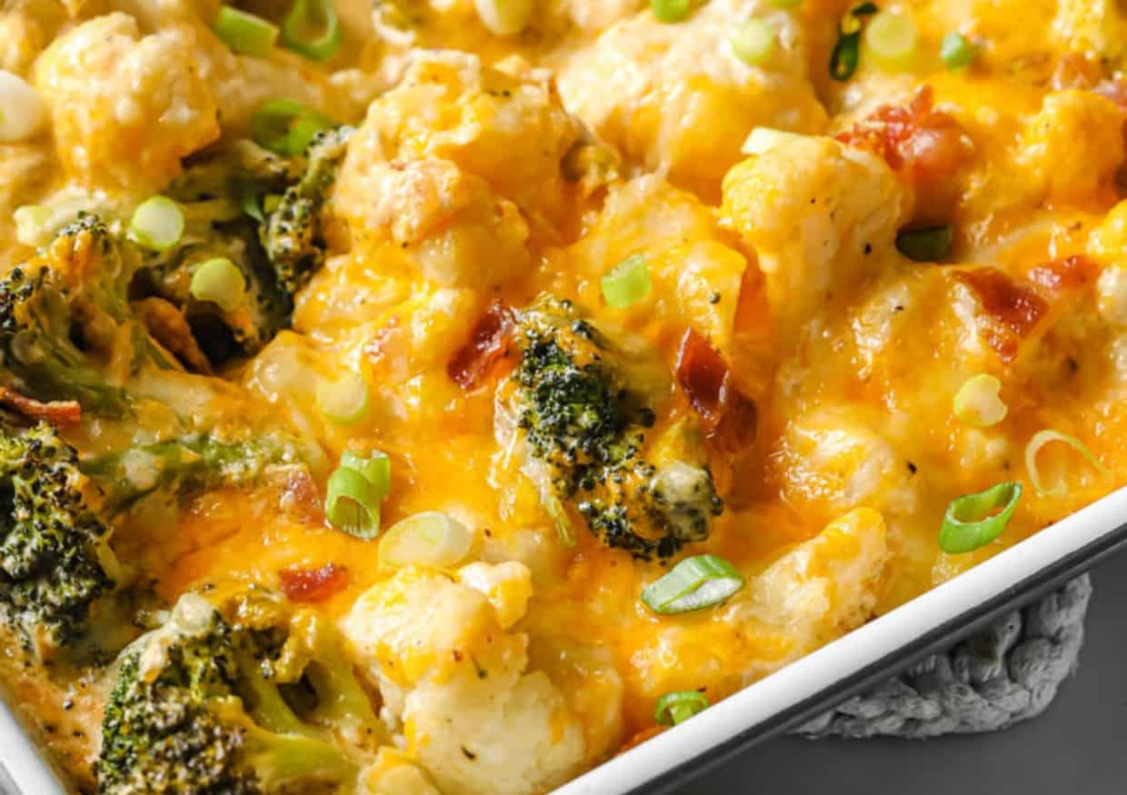 Loaded broccoli cauliflower casserole in a baking dish garnished with green onions.