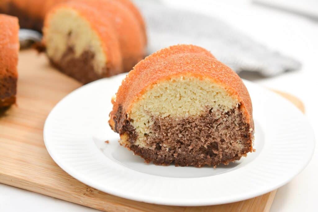 A bundt cake on a plate with a slice taken out.