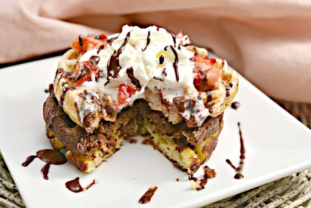 Chocolate waffles with whipped cream and strawberries.