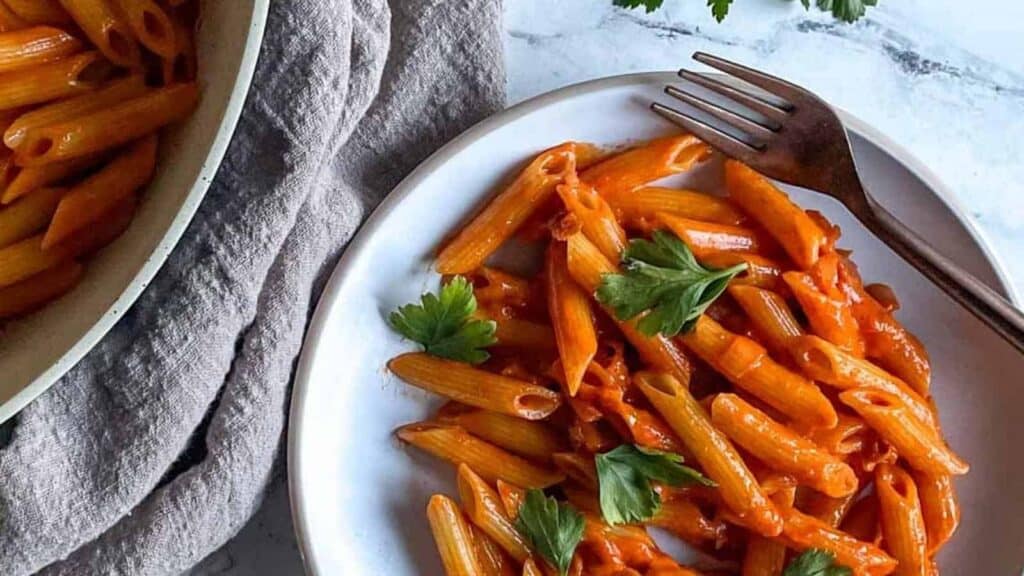 A plate of pasta with sauce and parsley.