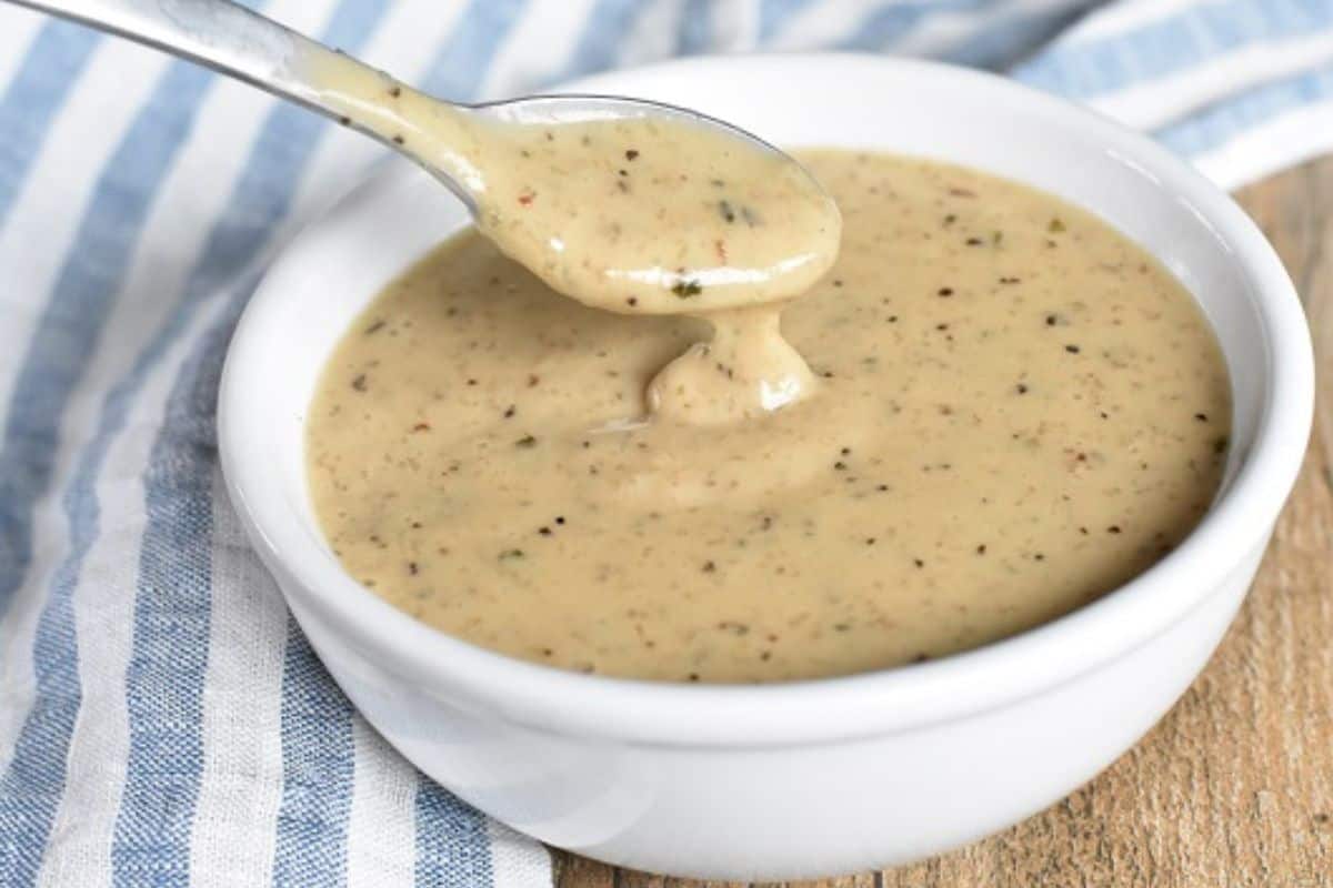 A spoonful of gravy in a white bowl.