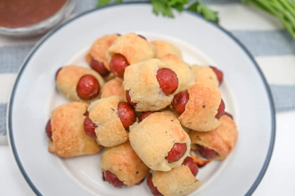 Hot dog buns with little smokies on a plate.