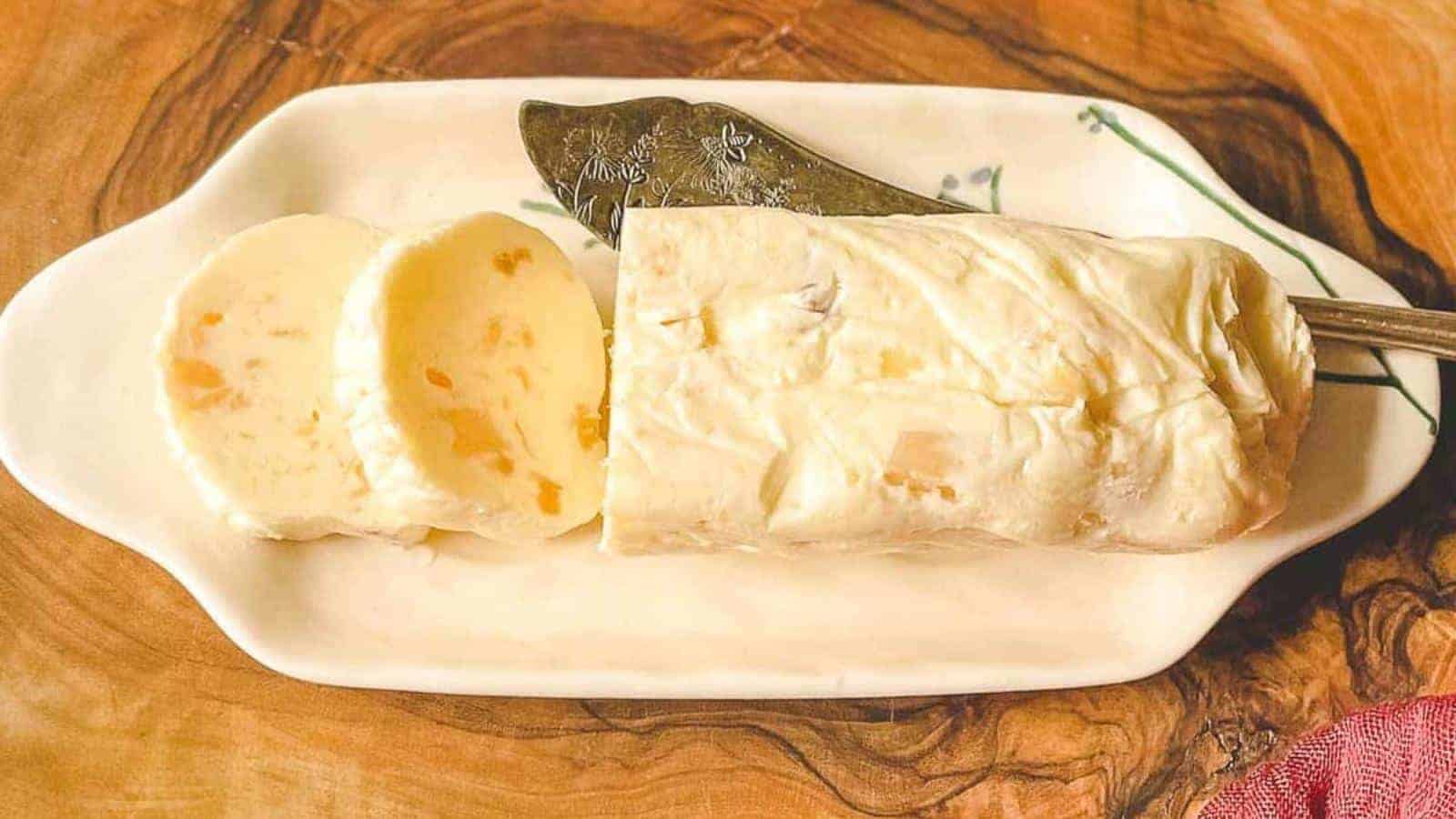 Roasted garlic butter on a white butter plate with a decorative silver knife.