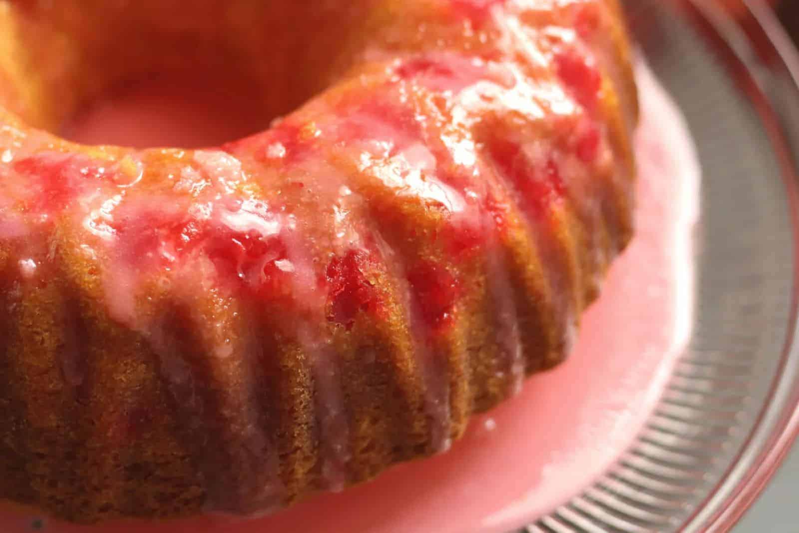 Shirley Temple cake with grenadine glaze on a glass cake stand.