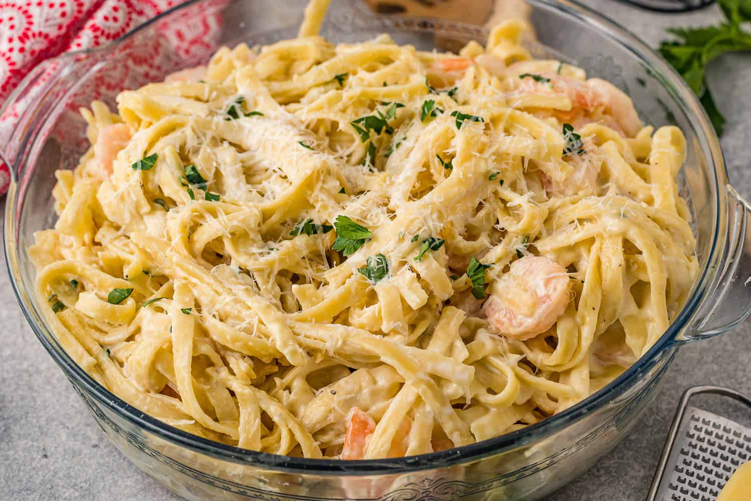 A bowl of pasta with shrimp and parmesan cheese.