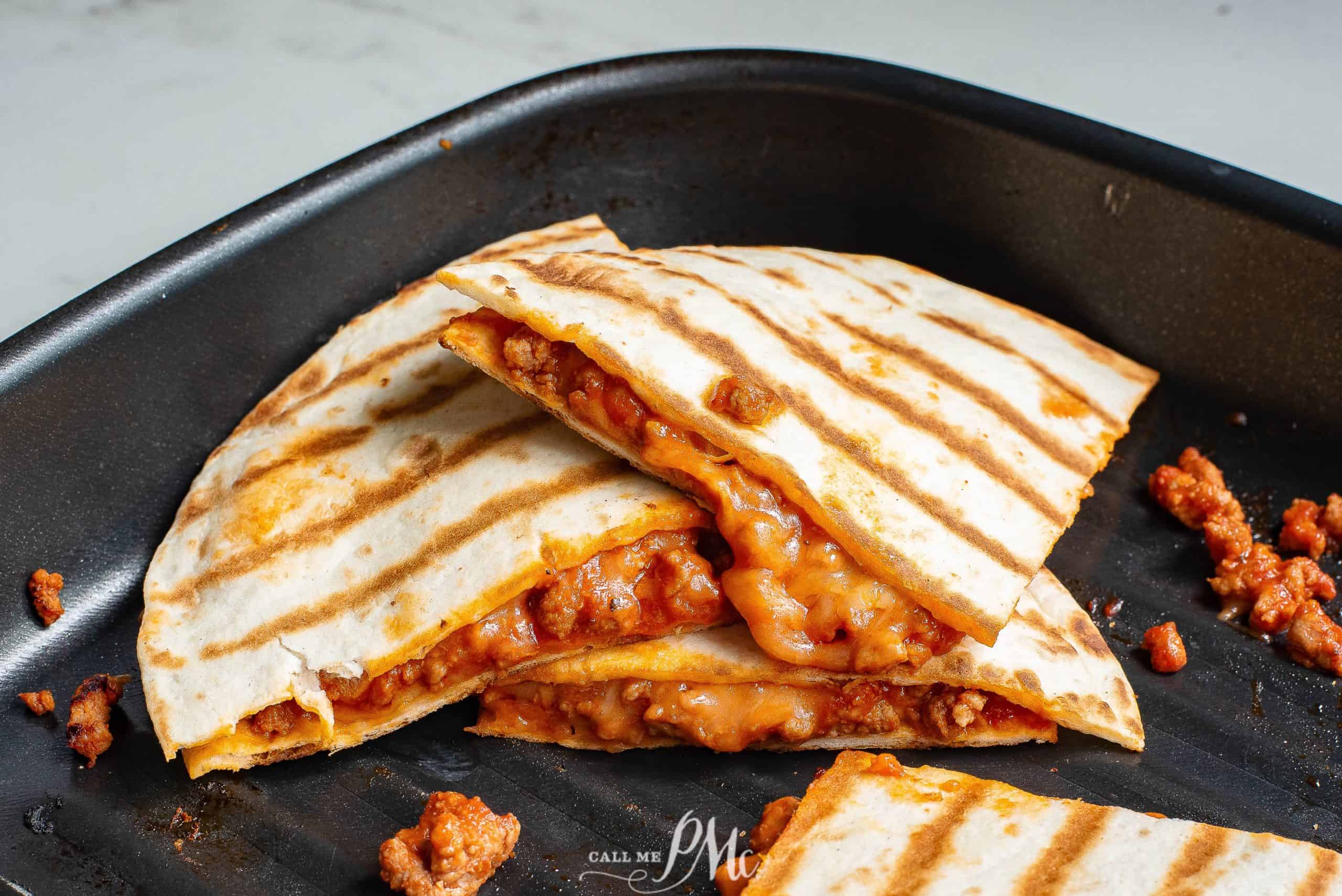 Sloppy Joe Quesadillas stacked in skillet.