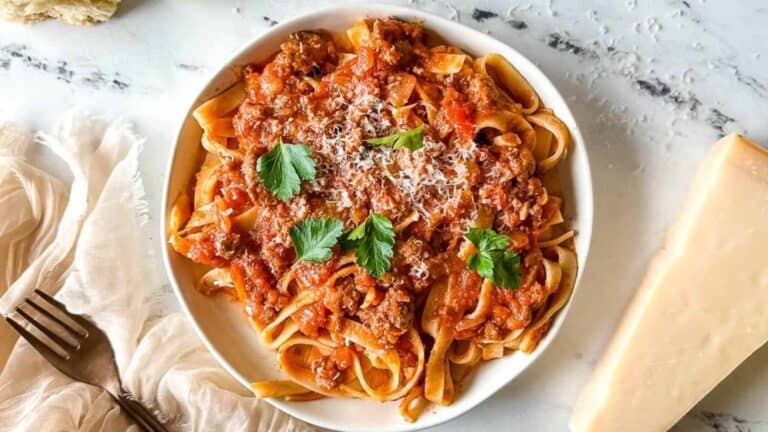 A bowl of spaghetti with meat sauce and parmesan cheese.