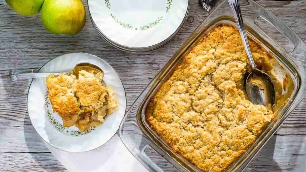 A dish of apple cobbler with apples on it.