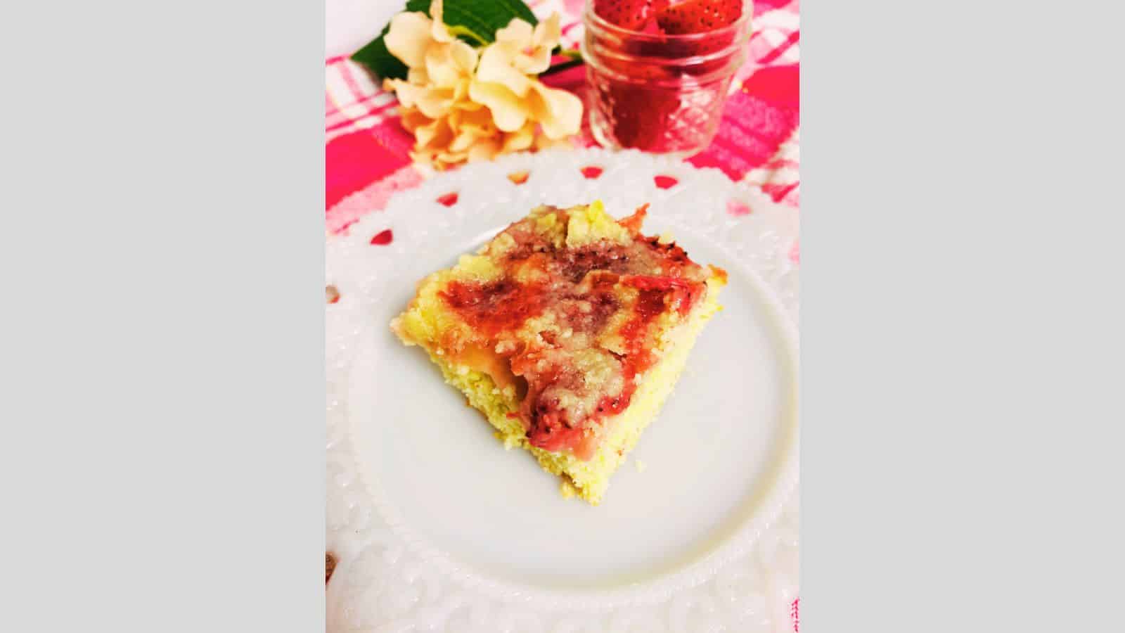 Slice of strawberry coffee cake on white plate.