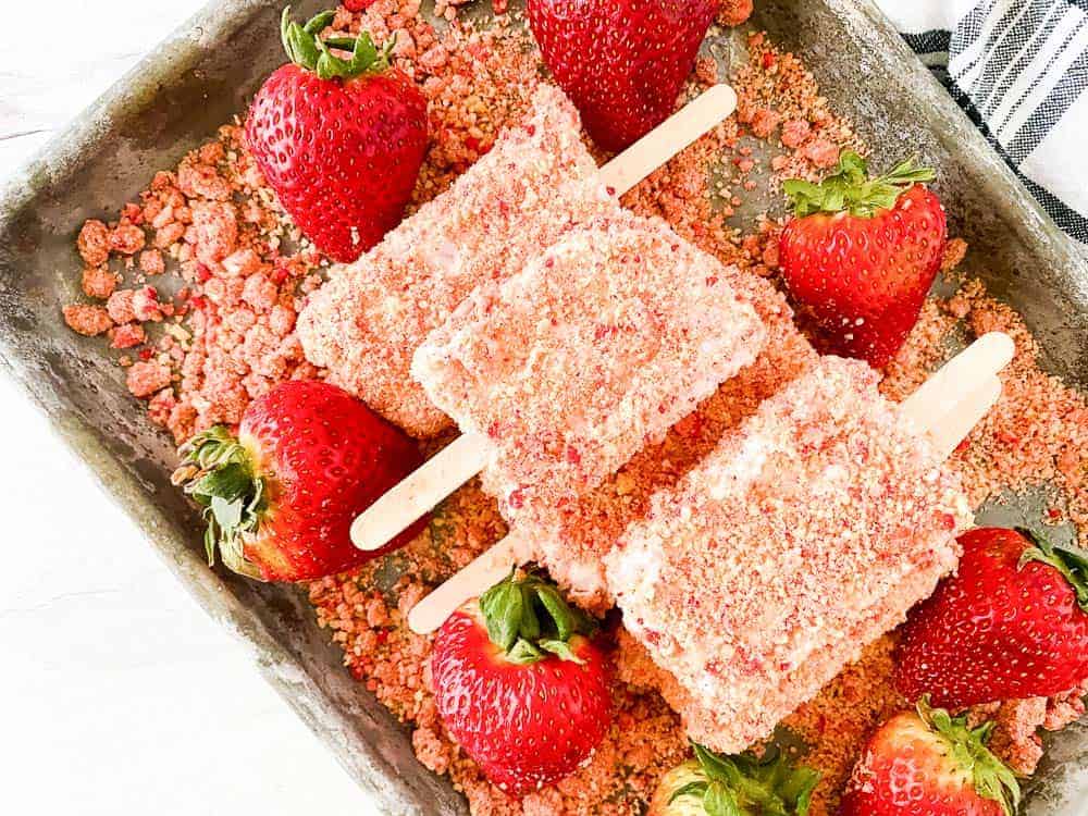 Strawberry popsicles on a baking sheet.