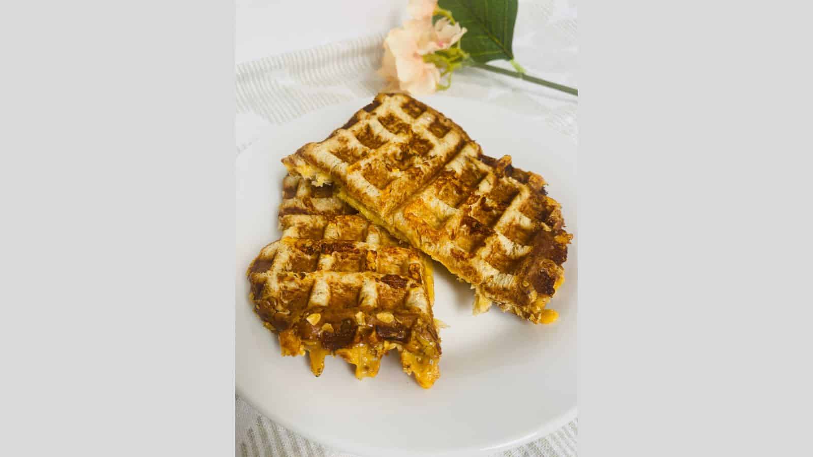 Waffle grilled cheese on a white plate with flowers.