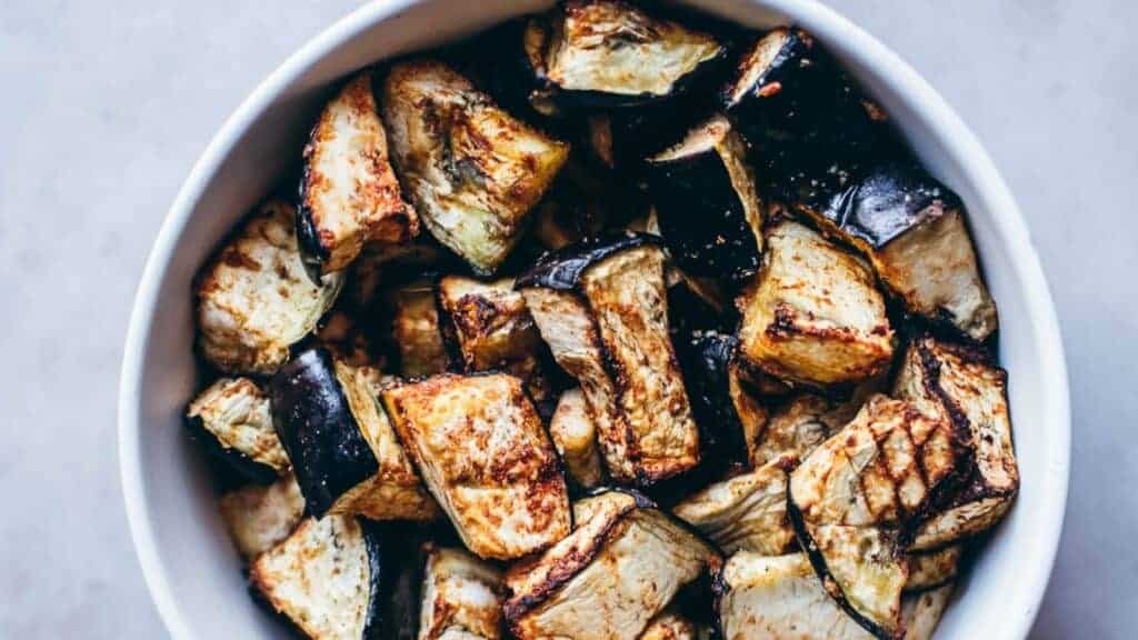 Grilled eggplant in a white bowl.