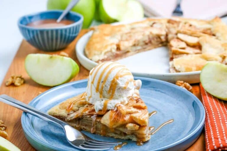 A slice of apple pie with ice cream on a plate.