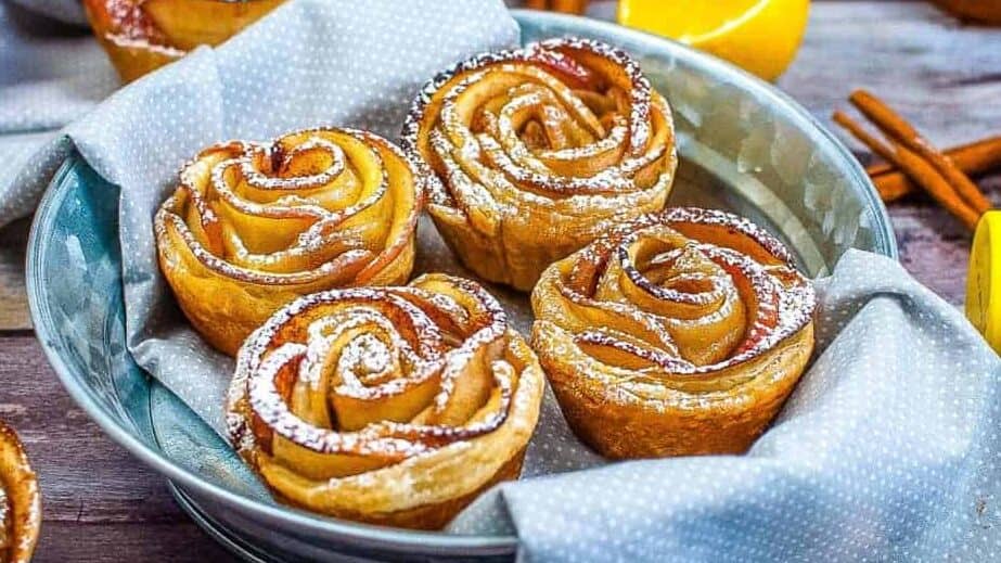 Air Fryer Apple Roses dusted with powdered sugar on a plate.