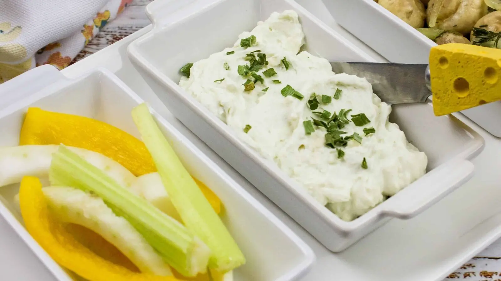 Blue cheese dip on a white small plate with buffalo wings on a white plate.