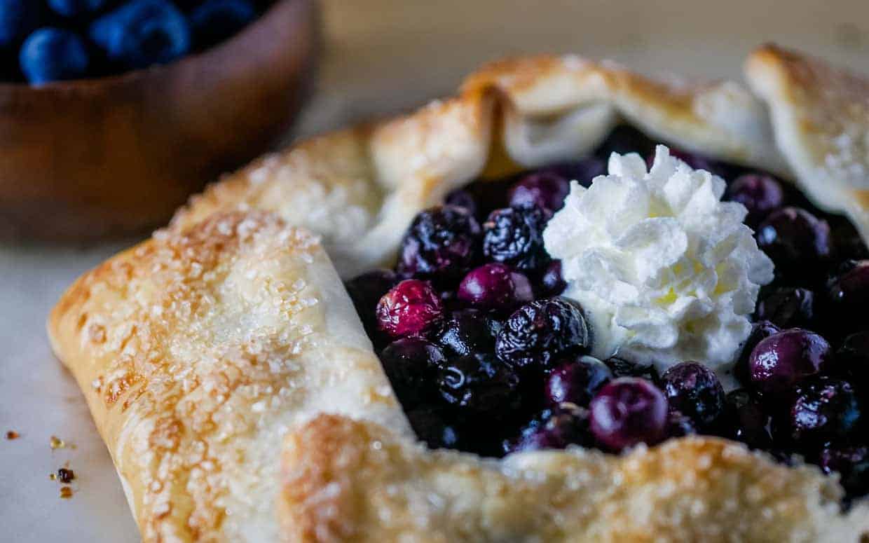 Blueberry galette topped with whipped cream.