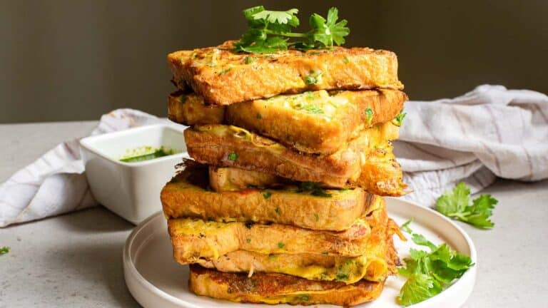 A stack of french toast topped with parsley.