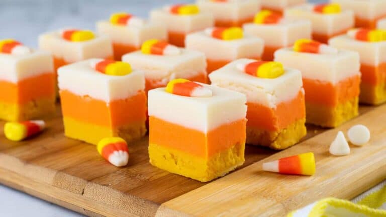 Candy corn cheesecake squares on a cutting board.