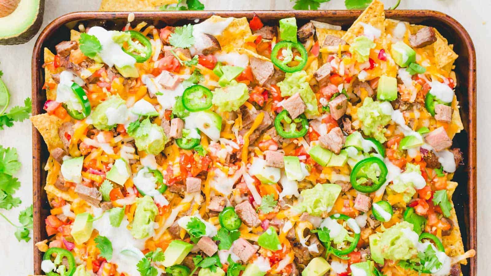 Carne asada nachos on a sheet pan.