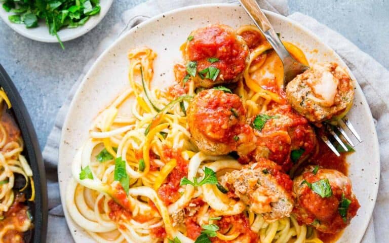 A plate of spaghetti with meatballs and sauce.