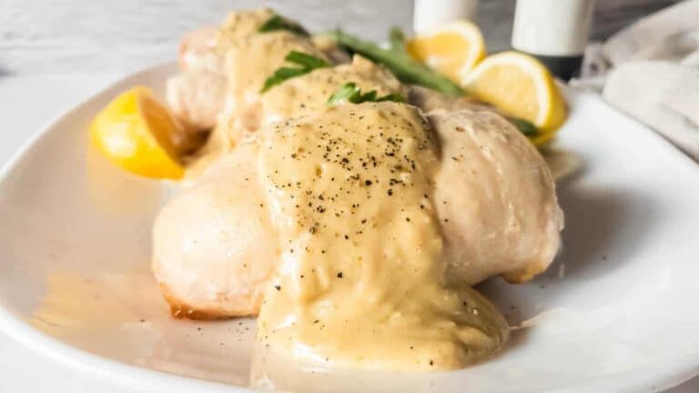 Chicken breasts with lemon sauce on a white plate.